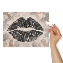Cargar imagen en el visor de la galería, Lip Print jigsaw puzzle featuring an oversized black lip impression on a layered neutral cream, taupe, gray and stone background, from Little Yellow Bungalow.
